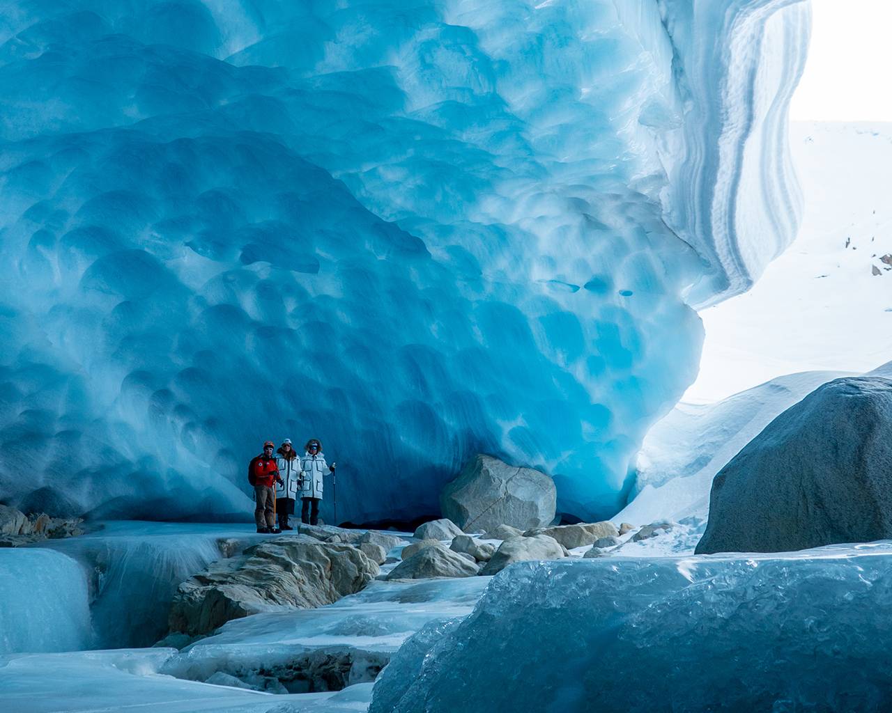 guide and guest inside an ice cave during a luxury ice cave tour