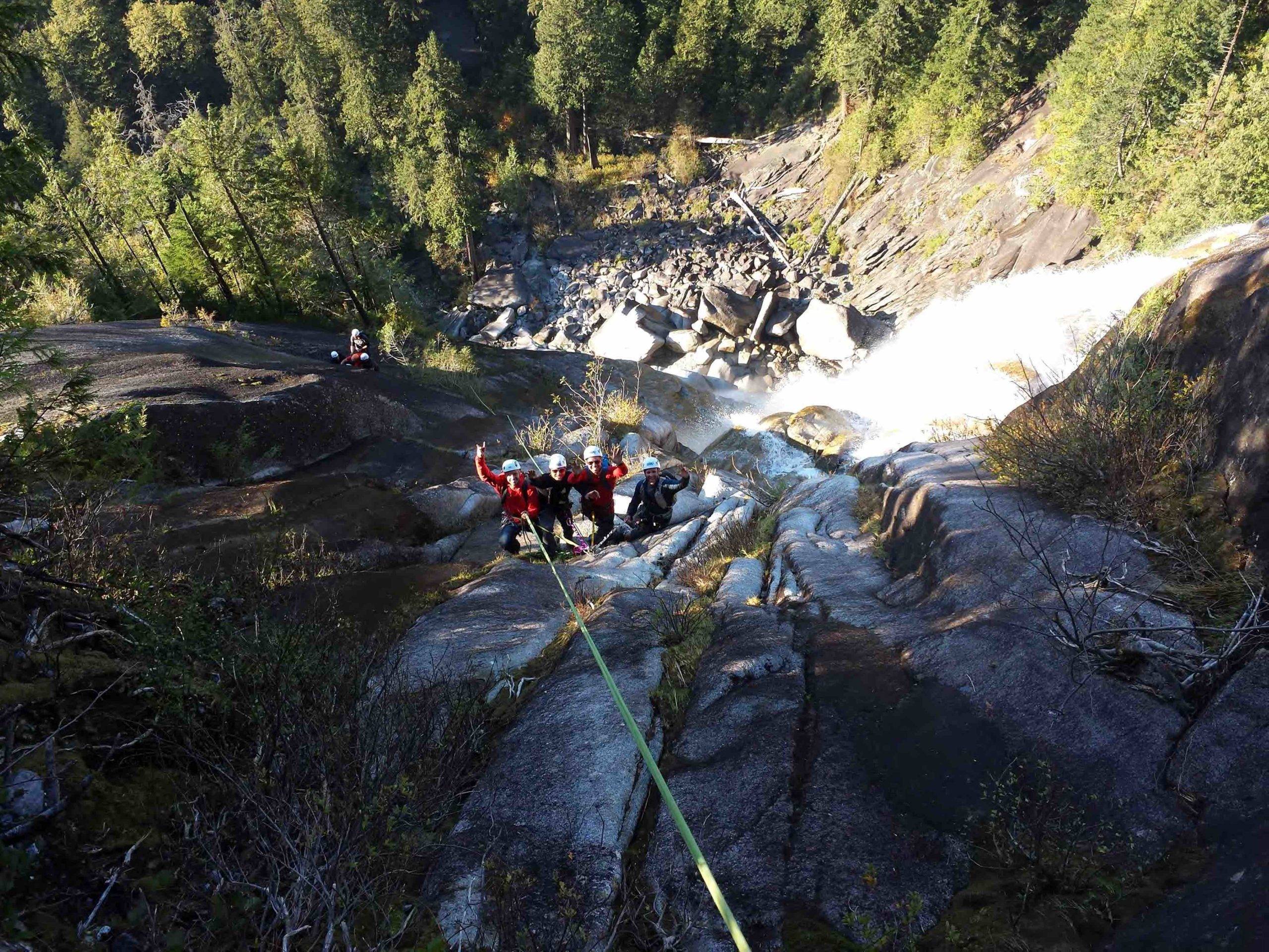 Group rappelling down waterfall with MSAA guide
