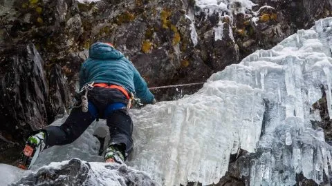 Male Climbing ice wall on blackcomb glacier during course